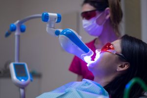 Laser Teeth Whitening Procedure in Dental Clinic with ultraviolet light UV lamp