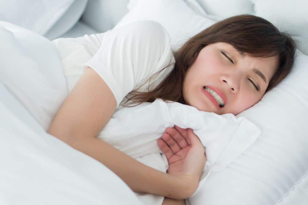 Stressed woman grinding her teeth while sleeping
